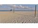 Scenic beach with a volleyball net under a partly cloudy sky at 976 Euclid Rd, Venice, FL 34293