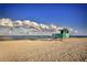 Scenic beach view featuring a lifeguard tower on the shoreline under a blue sky at 976 Euclid Rd, Venice, FL 34293