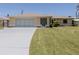 Charming home with a well-manicured lawn and a driveway leading to a two-car garage at 976 Euclid Rd, Venice, FL 34293