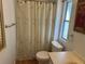 Bathroom featuring a toilet, shower with curtain, window, and neutral-toned countertop with sink at 103 Lakeview Dr, North Port, FL 34287