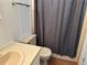 Bathroom featuring a toilet, shower with curtain, sink, hardware, and wood-look flooring at 103 Lakeview Dr, North Port, FL 34287