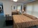 Bedroom with a large bed, mirrored closet doors, side tables with lamps, and an ottoman bench at 103 Lakeview Dr, North Port, FL 34287