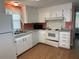Inviting kitchen with white appliances, cabinets, and laminate flooring at 103 Lakeview Dr, North Port, FL 34287