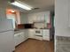 Well-lit kitchen with white cabinets, appliances, and light wood floors at 103 Lakeview Dr, North Port, FL 34287
