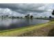 Picturesque lake view surrounded by homes and greenery under a cloudy sky at 103 Lakeview Dr, North Port, FL 34287