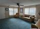 Comfortable living room featuring plush carpeting, a ceiling fan, and large windows at 103 Lakeview Dr, North Port, FL 34287