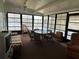 Sun room with panoramic lake views, casual seating, glass table, and ceiling fan at 103 Lakeview Dr, North Port, FL 34287