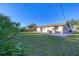 View of the backyard featuring lush green grass and a patio, ideal for outdoor activities and gatherings at 1032 Elaine St, Venice, FL 34285