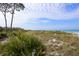 Picturesque beach view with dune grass, a pier, and a clear blue sky at 1032 Elaine St, Venice, FL 34285
