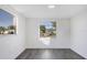 Bright bedroom with modern gray wood floors, white walls, and plenty of natural light from two large windows at 1032 Elaine St, Venice, FL 34285