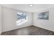 Inviting bedroom with gray wood floors, white walls, and two windows providing natural light at 1032 Elaine St, Venice, FL 34285