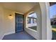 A closer view of the home's entrance with an arched porch and decorative front door with modern exterior lighting at 1032 Elaine St, Venice, FL 34285