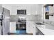 Close-up of a kitchen features stainless steel appliances, white cabinets, and marble backsplash at 1032 Elaine St, Venice, FL 34285