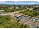Aerial view of a home featuring a screened-in pool and a spacious backyard in a residential neighborhood at 10444 Willmington Blvd, Englewood, FL 34224