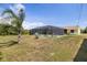 Home with backyard, screened pool, mature palm and utility pole at 10444 Willmington Blvd, Englewood, FL 34224