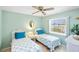 Cozy bedroom featuring twin beds, a ceiling fan, and a bright window at 10444 Willmington Blvd, Englewood, FL 34224
