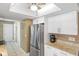 Modern kitchen featuring stainless steel refrigerator, white cabinetry, and granite countertops at 10444 Willmington Blvd, Englewood, FL 34224