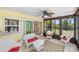 Sunroom with white wicker furniture overlooks the backyard and pool at 10444 Willmington Blvd, Englewood, FL 34224