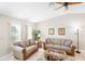 Bright living room offering tile flooring, a ceiling fan, and comfortable sofas at 10444 Willmington Blvd, Englewood, FL 34224