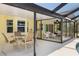 Covered outdoor patio with dining area and screened-in porch features at 10444 Willmington Blvd, Englewood, FL 34224
