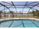 Beautiful in-ground pool surrounded by screened enclosure with lounge chairs outside at 10444 Willmington Blvd, Englewood, FL 34224