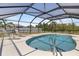 Private in-ground pool surrounded by a screened enclosure with sun loungers at 10444 Willmington Blvd, Englewood, FL 34224