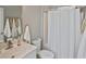 Bright bathroom featuring a shower with curtain, white toilet, and a marble sink at 1104 Auburn Cove Cir, Venice, FL 34292