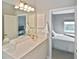 Bright bathroom with a large mirror, ample counter space, and a doorway to the bedroom at 1104 Auburn Cove Cir, Venice, FL 34292