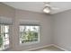 Light-filled bedroom featuring a ceiling fan and large windows with wooded views at 1104 Auburn Cove Cir, Venice, FL 34292