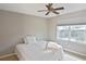 Cozy bedroom with ceiling fan, large window, and neutral color palette, perfect for relaxation at 1104 Auburn Cove Cir, Venice, FL 34292
