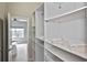 Walk in closet with built in shelving and open access to the bedroom at 1104 Auburn Cove Cir, Venice, FL 34292