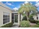 Charming home entrance with screened porch surrounded by tropical landscaping at 1104 Auburn Cove Cir, Venice, FL 34292