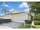 Inviting single-story home featuring a well-maintained lawn and a two-car garage at 1104 Auburn Cove Cir, Venice, FL 34292
