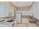 Well-equipped kitchen showcasing white cabinets, tile floors, and modern appliances at 1104 Auburn Cove Cir, Venice, FL 34292