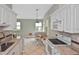 Updated kitchen with granite counters, white cabinets, modern appliances, and adjacent breakfast nook at 1104 Auburn Cove Cir, Venice, FL 34292