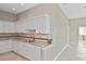 Bright kitchen featuring sleek countertops, stainless steel sink, and pristine white cabinetry at 1104 Auburn Cove Cir, Venice, FL 34292