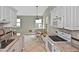 Kitchen featuring stainless steel appliances, white cabinetry, and a dining area at 1104 Auburn Cove Cir, Venice, FL 34292
