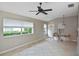 Bright living room featuring tile flooring, large windows, and a ceiling fan at 1104 Auburn Cove Cir, Venice, FL 34292