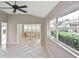 Living room with large windows offering a sun-filled room, tile floor and a ceiling fan at 1104 Auburn Cove Cir, Venice, FL 34292