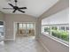 Inviting living room with tile floors, ceiling fan, and a view into the adjacent sun room at 1104 Auburn Cove Cir, Venice, FL 34292