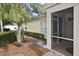 A patio with a screened-in porch, a palm tree, and lush landscaping at 1104 Auburn Cove Cir, Venice, FL 34292