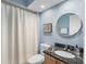 Cozy bathroom featuring a vanity with granite countertop, toilet, shower with curtain, and a round mirror at 114 Southampton N Pl # 237, Venice, FL 34293