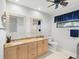Bright bathroom with double sink vanity, decorative mirrors, toilet, and a window for natural light at 114 Southampton N Pl # 237, Venice, FL 34293