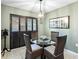 Cozy dining area featuring a glass table, stylish chairs, plantation shutters, and decorative lighting fixture at 114 Southampton N Pl # 237, Venice, FL 34293