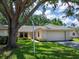 Charming single-story home with a well-manicured lawn, mature tree and a two-car garage at 114 Southampton N Pl # 237, Venice, FL 34293