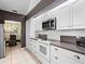 Modern kitchen featuring white cabinets, granite counters and stainless steel appliances with dining space access at 114 Southampton N Pl # 237, Venice, FL 34293