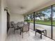 Screened lanai featuring a ceiling fan and outdoor furniture, perfect for enjoying the beautiful landscape views at 114 Southampton N Pl # 237, Venice, FL 34293