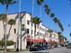 Shopping district showcasing a vintage facade with street parking lined with tall palm trees on a sunny day at 114 Southampton N Pl # 237, Venice, FL 34293