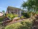 Backyard view featuring a screened-in patio surrounded by lush landscaping at 11649 Tempest Harbor Loop, Venice, FL 34292