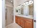 Bathroom featuring double sinks, ample lighting, and a glass-enclosed shower at 11649 Tempest Harbor Loop, Venice, FL 34292